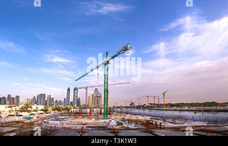 Baustelle mit großen Kran, modernes Gebäude in Dubai Business Bay, Baustelle am Sunset Hintergrund moderne Architektur