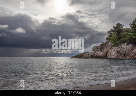 Spritzer von frischem Schäumen, sprudelnde Wasser, stürmischen Himmel, dunkle Wolken, White Crest von Wellen, steinige Küste von Montenegro. Adria. Stockfoto