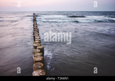 Holz- meer Wellenbrecher bei Sonnenuntergang, Farbe Tonen angewendet, langen Belichtungszeit. Stockfoto