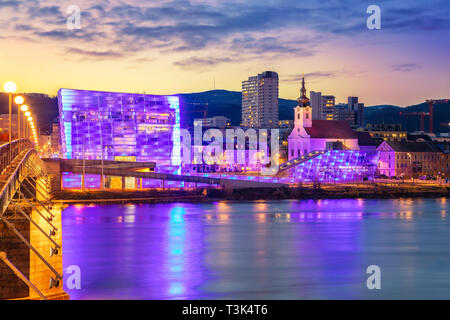 Linz, Österreich. Stadtbild Bild von Riverside Linz, Österreich während der Dämmerung blaue Stunde mit Reflexion auf die Lichter der Stadt in die Donau. Stockfoto