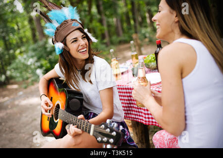 Eine Gruppe von Freunden ein Picknick im Park Outdoor. Glückliche junge Leute bbq genießen. Stockfoto