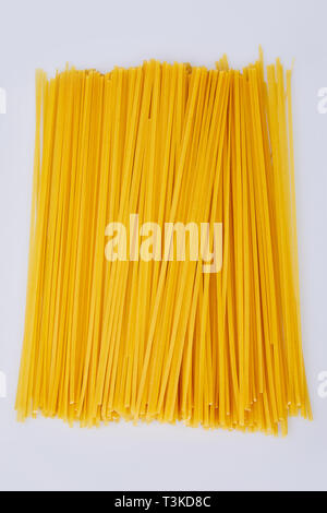 Spaghetti isoliert auf weißem Hintergrund. Gelbe Garbe raw lange Teigwaren, bereit, für das Kochen. Italienischen Pasta. Lange Spaghetti. Rohe spaghetti bolognese Stockfoto