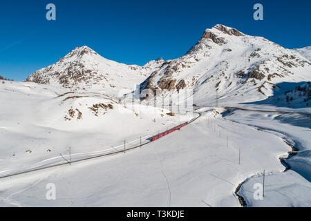 Bernina Express, Roten Zug in der Wintersaison. Panoramablick auf den Bernina Pass Stockfoto