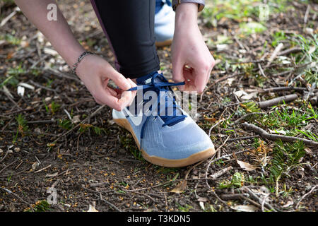 Junge Frau trainer Schnürsenkel binden, bevor sie für einen Lauf Stockfoto