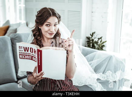 Frau mit einem Hochzeitskleid vail ein Buch lesen Stockfoto