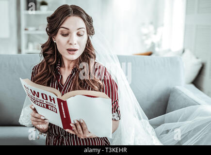 Frau mit einem Hochzeitskleid vail Lesen einer Zeitschrift Stockfoto