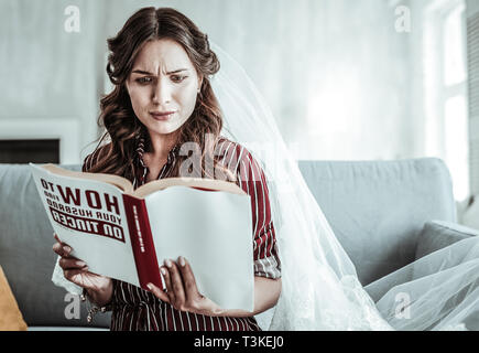Frau in einem vail Lesung über die Ehe Stockfoto