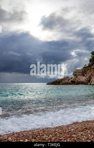 Spritzer von frischem Schäumen, sprudelnde Wasser, stürmischen Himmel, dunkle Wolken, White Crest von Wellen, steinige Küste von Montenegro. Adria. Stockfoto