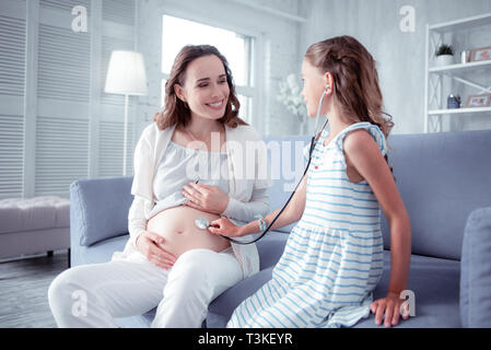 Erwartet Frau Gefühl glücklich spielen mit älteren Tochter Stockfoto