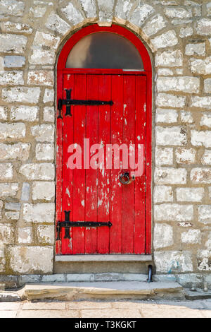 Eine rote gewölbter Deckel Tür mit abblätternder Farbe schwarz Scharniere und am Eingang zu Gibraltar malen Leuchtturm auf Toronto Island ist in Toronto, Kanada. Stockfoto