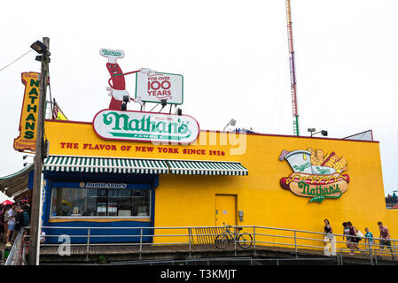 New York City, USA - 30. Juli 2018: Restaurant namens Nathans im Luna Park Vergnügungspark mit Menschen zu Fuß an der Strandpromenade von Coney Island Bea Stockfoto