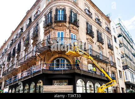 Drei Männer auf einer Houlotte HA 16 PX Einziehwerk Reparatur einer Metall Balkon in Sevilla, Spanien Stockfoto