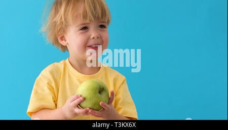 Kleiner Junge hält einen großen grünen apple Stockfoto