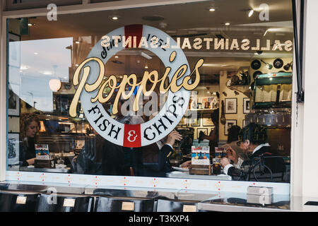 London, UK - April 6, 2019: Blick durch das Fenster der Menschen innerhalb der Poppie in Spitalfields, London, einem berühmten Fish & Chips shop, servin wurde Stockfoto