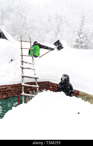 Wanderer freiwillig helfen den Schnee in einem abgelegenen Kloster auf dem Hauptweg auf 1400 m Höhe im Nationalpark Retezat, Rumänien entfernt Schaufeln, Stockfoto