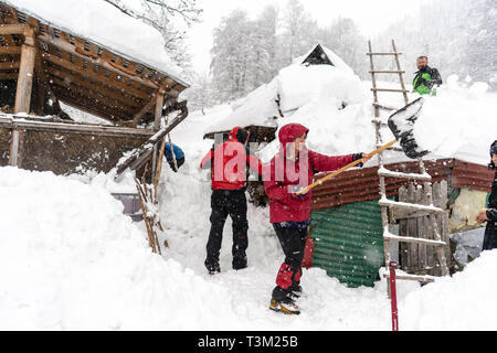 Wanderer freiwillig helfen den Schnee in einem abgelegenen Kloster auf dem Hauptweg auf 1400 m Höhe im Nationalpark Retezat, Rumänien entfernt Schaufeln, Stockfoto