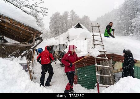 Wanderer freiwillig helfen den Schnee in einem abgelegenen Kloster auf dem Hauptweg auf 1400 m Höhe im Nationalpark Retezat, Rumänien entfernt Schaufeln, Stockfoto