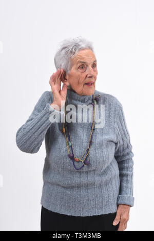 Ältere Frau eine Hand auf ihr Ohr, weil Sie nicht auf weißem Hintergrund hören Stockfoto