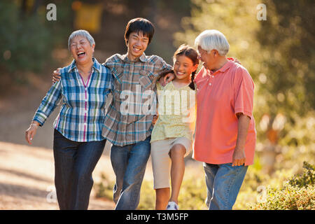 Lächelnd senior Paar Arm in Arm mit ihren Enkelkindern. Stockfoto