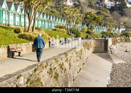 LANGLAND BAY, Gower, WALES - Februar 2019: Person zu Fuß entlang der Promenade im Sonnenschein in Langland Bay auf der Gower Peninsula in Wales. Stockfoto