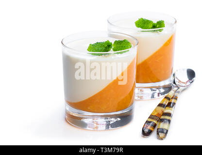 Panna cotta mit orange Jelly in Klarglas isoliert auf weißem Stockfoto
