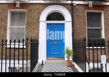 Stadthaus in Gentrifizierten London mit blauer Tür, Fenster und schwarz Geländer auf beiden Seiten der Tür Stockfoto