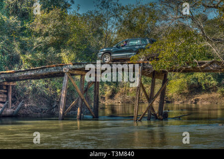 Touristen mit dem Auto auf einer großen, klapprige Holzbrücke mitten in der Wildnis von Paraguay. Stockfoto