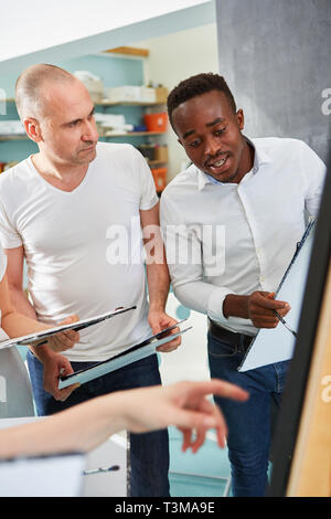 Afrikanische Künstler und Kunststudenten zusammen an der Staffelei im Atelier Stockfoto