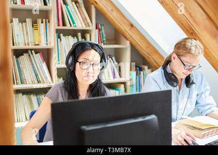 Zwei Frauen arbeiten an e-Learning an den Computer in der Volkshochschule Bibliothek Stockfoto