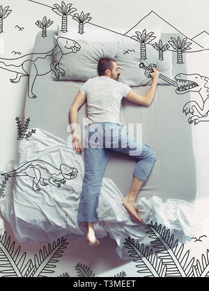 Zurück in die Zeit der Dinosaurier. Ansicht von oben Foto des jungen Mannes schlafen in einem großen weißen Bett zu Hause. Träume Konzept. Malte Traum über Landschaften, prähistorische Abenteuer, Kampf, Berge, Schwert, Schutz. Stockfoto