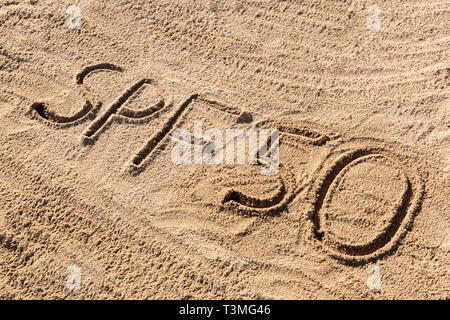 Sun Schutz Faktor 50 Konzept. SPF 50 Wort am Strand geschrieben. Stockfoto