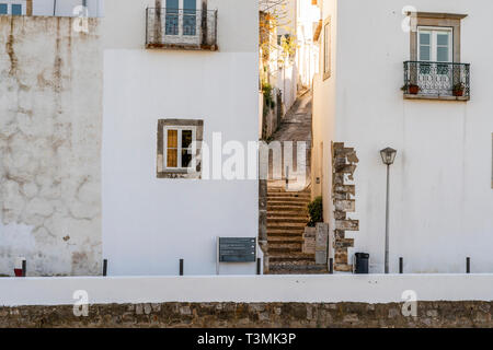 Schmale Straße bergauf, das zwischen zwei weiße Häuser in Tavira, Algarve, Portugal Stockfoto