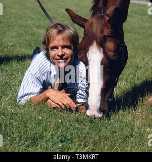 Thomas Fritsch, deutscher Wis und Synchronsprecher, mit Pferd, Deutschland Ca. 1987. Deutsche Schauspieler Synchronisation und Schauspieler Thomas Fritsch mit einem Pferd, Deutschland Ca. 1987. Stockfoto