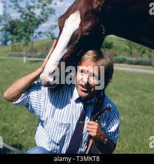 Thomas Fritsch, deutscher Wis und Synchronsprecher, mit Pferd, Deutschland Ca. 1987. Deutsche Schauspieler Synchronisation und Schauspieler Thomas Fritsch mit einem Pferd, Deutschland Ca. 1987. Stockfoto