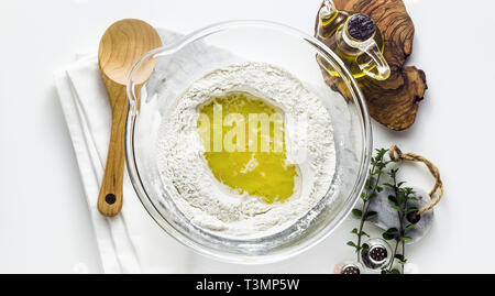 Banner von kneten den Teig für Pasta. Original italienische Rezeptur. Mehl semolino mit Wasser und Olivenöl. Auf dem Tisch in einer Glasschale Stockfoto