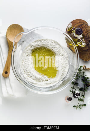 Kneten den Teig für Pasta. Original italienische Rezeptur. Mehl semolino mit Wasser und Olivenöl. Auf dem Tisch in einer Glasschale Stockfoto