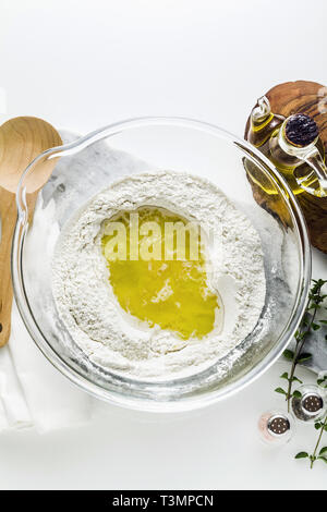 Kneten den Teig für Pasta. Original italienische Rezeptur. Mehl semolino mit Wasser und Olivenöl. Auf dem Tisch in einer Glasschale Stockfoto