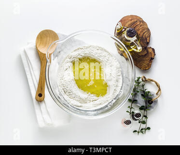 Kneten den Teig für Pasta. Original italienische Rezeptur. Mehl semolino mit Wasser und Olivenöl. Auf dem Tisch in einer Glasschale Stockfoto