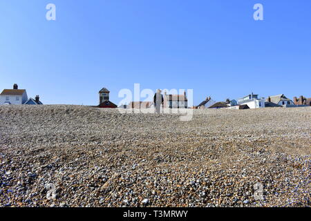 Sie suchen den steilen Kiesstrand in Richtung einer Dame nach unten wandern, Aldeburgh, Suffolk, England Stockfoto