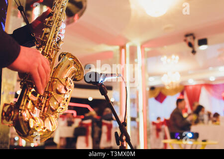 Goldene Saxophon in die Hände eines Musikers in der Nähe des Mikrofons Stockfoto