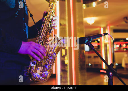 Goldene Saxophon in die Hände eines Musikers in der Nähe des Mikrofons Stockfoto