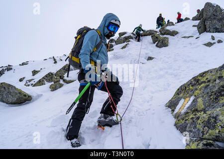 Gruppe von Alpinisten aufsteigen und erreichen eine der spektakulärsten Gipfel im Retezat Nationalpark, Rumänien Stockfoto