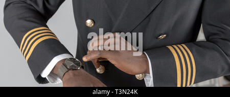 England, UK, April 2019. Airline Pilot Kontrolle Zeit auf seine Armbanduhr. Stockfoto