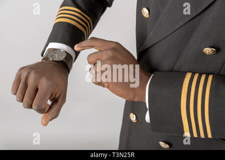 England, UK, April 2019. Airline Pilot Kontrolle Zeit auf seine Armbanduhr. Stockfoto