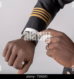 England, UK, April 2019. Airline Pilot Kontrolle Zeit auf seine Armbanduhr. Stockfoto