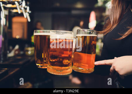 Womans Hand gießen Pint Bier hinter der Bar Stockfoto