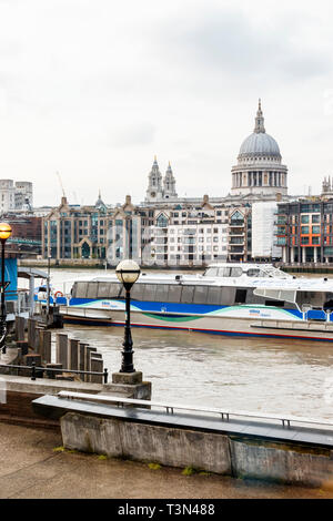 Ein Thames Clipper Docks an Bankside Pier, London, UK, die St Paul's Kathedrale im Hintergrund Stockfoto