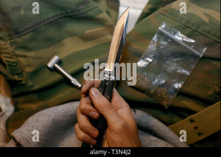 Ein junger Mann mit einem balisong oder Butterfly Messer für Schutz auf einer Straße in Newport, South Wales. 09/07/2006 Stockfoto