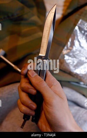 Ein junger Mann mit einem balisong oder Butterfly Messer für Schutz auf einer Straße in Newport, South Wales. 09/07/2006 Stockfoto