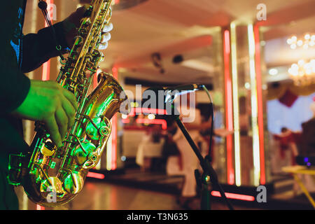 Goldene Saxophon in die Hände eines Musikers in der Nähe des Mikrofons Stockfoto